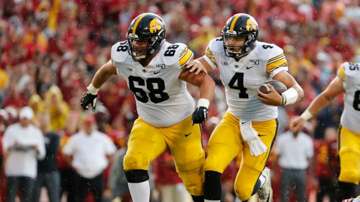 AMES, IA - SEPTEMBER 14: Quarterback Nate Stanley #4 of the Iowa Hawkeyes scrambles for yards while offensive lineman Landan Paulsen #68 of the Iowa Hawkeyes blocks in the quarter half of play against the Iowa State Cyclones at Jack Trice Stadium on September 14, 2019 in Ames, Iowa. (Photo by David Purdy/Getty Images)