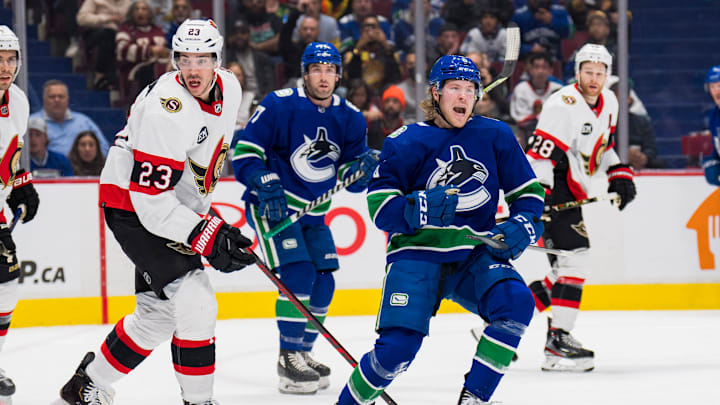 Apr 19, 2022; Vancouver, British Columbia, CAN; Ottawa Senators defenseman Travis Hamonic (23) looks on as Vancouver Canucks forward Brock Boeser (6) celebrates his goal in the first period at Rogers Arena. Mandatory Credit: Bob Frid-USA TODAY Sports