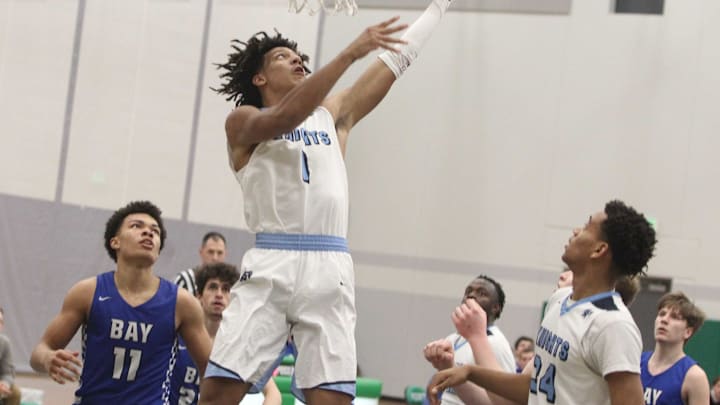 Nicolet’s Jalen Johnson scores two of his 17 points during the Knights’ 77-52 sectional semifinal victory over Whitefish Bay at Port Washington High School on March 12, 2020.Nicolet 1 March 12 2020