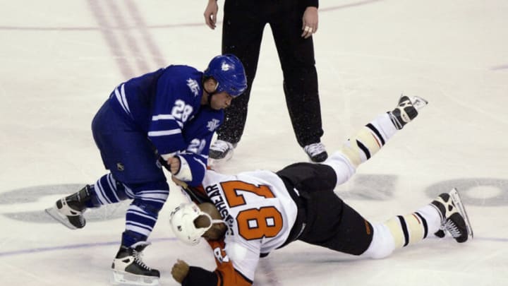 Tie Domi #28 of the Toronto Maple Leafs punishes Donald Brashear #87 of the Philadelphia Flyers in a fight during round one of the 2003 Stanley Cup playoffs on April 11, 2003 (Photo by Ezra Shaw/Getty Images/NHLI)