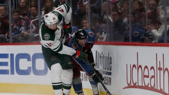 DENVER, CO - OCTOBER 04: Eric Fehr #21 of the Minnesota Wild fights for the puck on the boards with Tyson Barrie #4 of the Colorado Avalanche at the Pepsi Center on October 4, 2018 in Denver, Colorado. (Photo by Matthew Stockman/Getty Images)