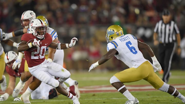 PALO ALTO, CA - SEPTEMBER 23: Bryce Love #20 of the Stanford Cardinal carries the ball while looking to avoid the tackle of Adarius Pickett #6 of the UCLA Bruins during the first quarter of their NCAA football game at Stanford Stadium on September 23, 2017 in Palo Alto, California. (Photo by Thearon W. Henderson/Getty Images)