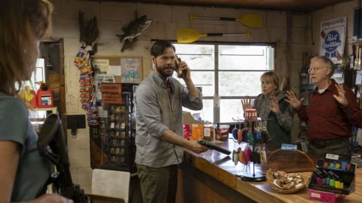 (from left) Members of the hunted (Kate Nowlin, back to camera, Ike Barinholtz), seek help from the owners of a gas station (Amy Madigan, Reed Birney) in "The Hunt," directed by Craig Zobel.