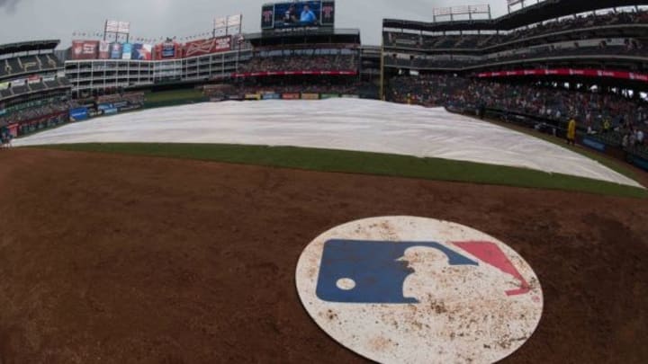 A view of the MLB logo and on deck circle and covered field during a rain delay in the game between the Texas Rangers and the Minnesota Twins at Globe Life Park in Arlington. The Rangers defeated the Twins 11-7. Mandatory Credit: Jerome Miron-USA TODAY Sports