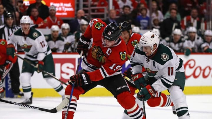 CHICAGO, IL - JANUARY 15: Jonathan Toews #19 of the Chicago Blackhawks tries to control the puck under pressure from Zach Parise #11 of the Minnesota Wild at the United Center on January 15, 2017 in Chicago, Illinois. The Wild defeated the Blackhawks 3-2. (Photo by Jonathan Daniel/Getty Images)
