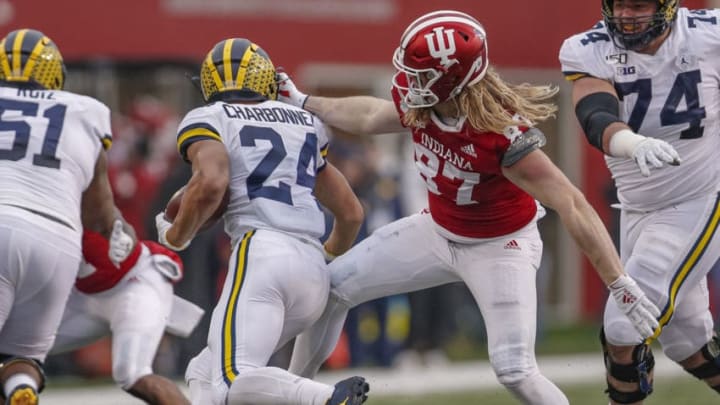 BLOOMINGTON, IN - NOVEMBER 23: Jack Cardillo #87 of the Indiana Hoosiers grabs the face mask of Zach Charbonnet #24 of the Michigan Wolverines during the first halfat Memorial Stadium on November 23, 2019 in Bloomington, Indiana. (Photo by Michael Hickey/Getty Images)