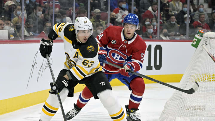 Apr 24, 2022; Montreal, Quebec, CAN; Boston Bruins forward Brad Marchand (63) plays the puck, and Montreal Canadiens defenseman Jordan Harris (54) defends during the first period at the Bell Centre. Mandatory Credit: Eric Bolte-USA TODAY Sports