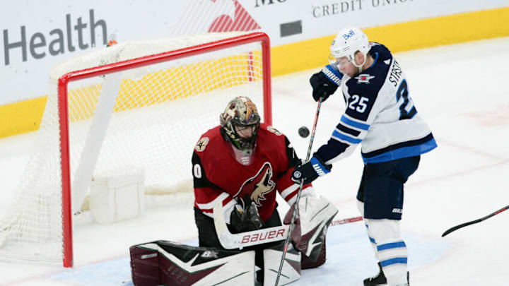 Jan 4, 2022; Glendale, Arizona, USA; Winnipeg Jets center Paul Stastny (25) is unable to tip a shot past Arizona Coyotes goaltender Karel Vejmelka (70) during the third period at Gila River Arena. Mandatory Credit: Joe Camporeale-USA TODAY Sports