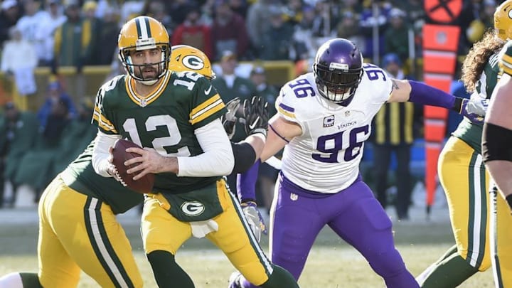 Dec 24, 2016; Green Bay, WI, USA; Green Bay Packers quarterback Aaron Rodgers (12) scrambles away from Minnesota Vikings defensive end Brian Robison (96) in the second quarter at Lambeau Field. Mandatory Credit: Benny Sieu-USA TODAY Sports