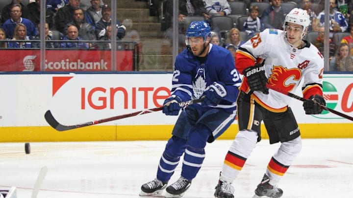 TORONTO, ON - OCTOBER 29: Josh Leivo #32 of the Toronto Maple Leafs gets a shot away while being covered by Sean Monahan #23 of the Calgary Flames during an NHL game at Scotiabank Arena on October 29, 2018 in Toronto, Ontario, Canada. The Flames defeated the Maple Leafs 3-1. (Photo by Claus Andersen/Getty Images)
