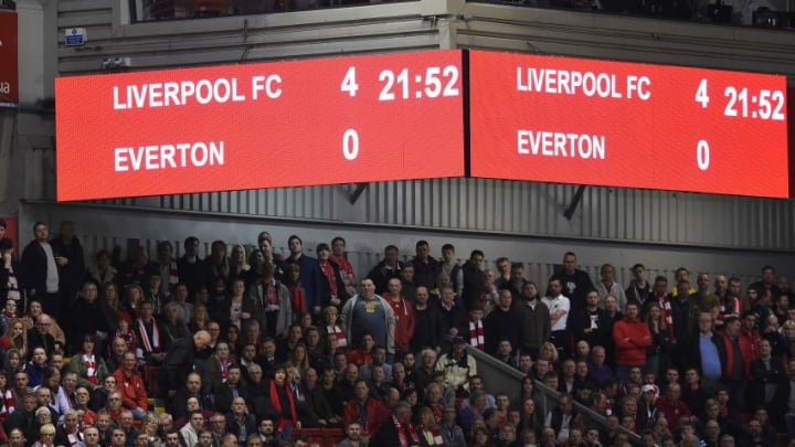 Liverpool fans watch the match with the scoreboard showing the final score during the English Premier League football match between Liverpool and Everton at Anfield in Liverpool, north west England on April 20, 2016. / AFP / PAUL ELLIS / RESTRICTED TO EDITORIAL USE. No use with unauthorized audio, video, data, fixture lists, club/league logos or 'live' services. Online in-match use limited to 75 images, no video emulation. No use in betting, games or single club/league/player publications. / (Photo credit should read PAUL ELLIS/AFP/Getty Images)