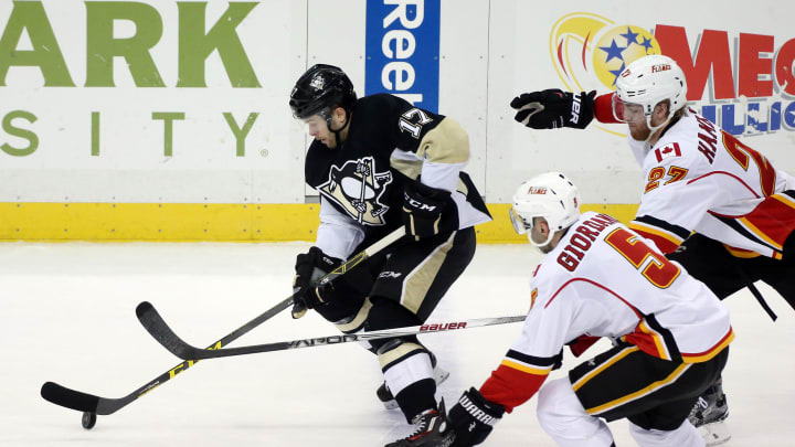 Mar 5, 2016; Pittsburgh, PA, USA; Pittsburgh Penguins right wing Bryan Rust (17) skates with the puck as Calgary Flames defenseman Mark Giordano (5) and defenseman Dougie Hamilton (27) chase during the second period at the CONSOL Energy Center. Mandatory Credit: Charles LeClaire-USA TODAY Sports