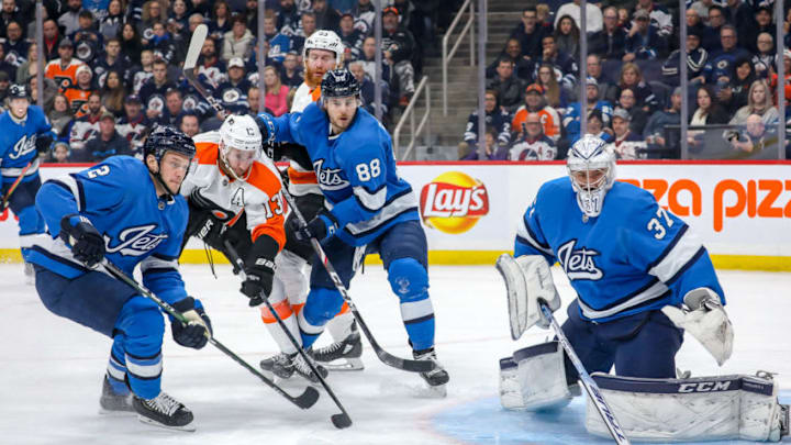 WINNIPEG, MB - DECEMBER 15: Anthony Bitetto #2, Nathan Beaulieu #88, goaltender Connor Hellebuyck #37 of the Winnipeg Jets and Kevin Hayes #13 of the Philadelphia Flyers eye the loose puck during first period action at the Bell MTS Place on December 15, 2019 in Winnipeg, Manitoba, Canada. (Photo by Jonathan Kozub/NHLI via Getty Images)