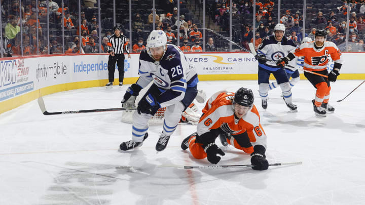 Travis Sanheim tussles with Blake Wheeler for a lose puck near the Flyers’ net. (Photo by Tim Nwachukwu/Getty Images)