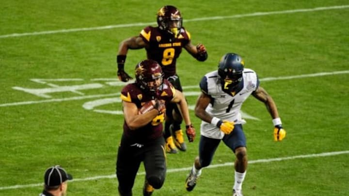 Jan 2, 2016; Phoenix, AZ, USA; Arizona State Sun Devils linebacker Salamo Fiso (58) returns an interception as cornerback Lloyd Carrington (8) looks on and West Virginia Mountaineers wide receiver Shelton Gibson (1) defends during the first half at Chase Field during the Cactus Bowl. Mandatory Credit: Matt Kartozian-USA TODAY Sports