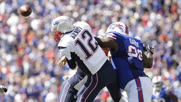 Sep 8, 2013; Orchard Park, NY, USA; Buffalo Bills defensive tackle Marcell Dareus (99) hits New England Patriots quarterback Tom Brady (12) as he throws a pass during the second quarter at Ralph Wilson Stadium. Mandatory Credit: Kevin Hoffman-USA TODAY Sports