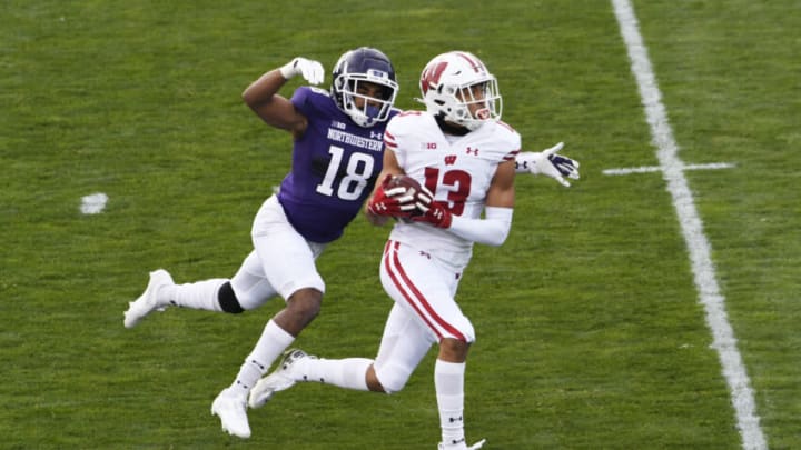 Nov 21, 2020; Evanston, Illinois, USA; Wisconsin Badgers wide receiver Chimere Dike (13) catches a touchdown pass as Northwestern Wildcats defensive back Cameron Ruiz (18) defends him during the first half at Ryan Field. Mandatory Credit: David Banks-USA TODAY Sports