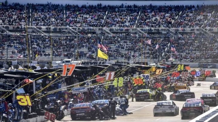 Apr 2, 2016; Martinsville, VA, USA; NASCAR Sprint Cup Series cars make an early pit stop during the Alpha Energy Solutions 250 at Martinsville Speedway. Mandatory Credit: Michael Shroyer-USA TODAY Sports