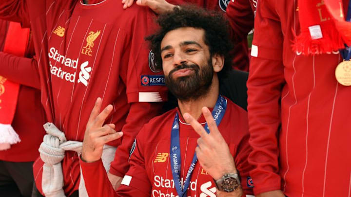 Liverpool's Egyptian midfielder Mohamed Salah gestures to the fans during an open-top bus parade around Liverpool, north-west England on June 2, 2019, after winning the UEFA Champions League final football match between Liverpool and Tottenham. - Liverpool's celebrations stretched long into the night after they became six-time European champions with goals from Mohamed Salah and Divock Origi to beat Tottenham -- and the party was set to move to England on Sunday where tens of thousands of fans awaited the team's return. The 2-0 win in the sweltering Metropolitano Stadium delivered a first trophy in seven years for Liverpool, and -- finally -- a first win in seven finals for coach Jurgen Klopp. (Photo by Oli SCARFF / AFP) (Photo credit should read OLI SCARFF/AFP/Getty Images)