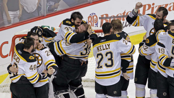 VANCOUVER - JUNE 15: Bruins goalie Tim Thomas hoists teammate Patrice Bergeron at left as the Bruins celebrate their victory. The Boston Bruins visited the Vancouver Canucks for Game Seven of the Stanley Cup Finals at the Rogers Arena. (Photo by Jim Davis/The Boston Globe via Getty Images)
