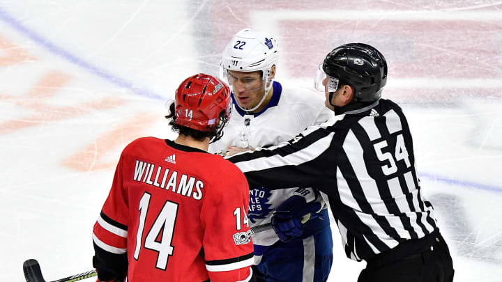 RALEIGH, NC – NOVEMBER 24: Linesman Greg Devosrki #54 separates Justin Williams #14 of the Carolina Hurricanes and Nikita Zaitsev #22 of the Toronto Maple Leafs during their game at PNC Arena on November 24, 2017 in Raleigh, North Carolina. Toronto won 5-4. (Photo by Grant Halverson/Getty Images)