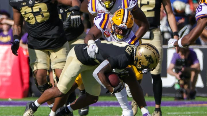 Jan 2, 2023; Orlando, FL, USA; Purdue Boilermakers wide receiver TJ Sheffield (8) is tackled by LSU Tigers linebacker Greg Penn III (30) during the second quarter at Camping World Stadium. Mandatory Credit: Mike Watters-USA TODAY Sports