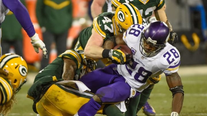 Jan 3, 2016; Green Bay, WI, USA; Minnesota Vikings running back Adrian Peterson (28) tries to break a tackle by Green Bay Packers linebacker Jake Ryan (47) in the fourth quarter at Lambeau Field. Mandatory Credit: Benny Sieu-USA TODAY Sports