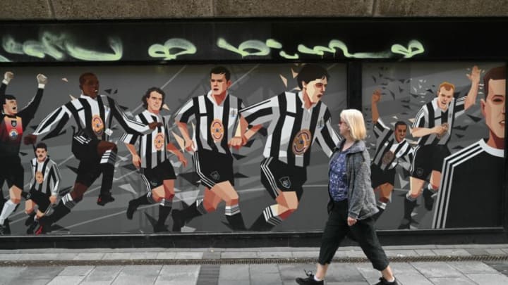 A pedestrian passes a Newcastle United football club-themed mural in Newcastle upon Tyne in northeast England on October 8, 2021. - A Saudi-led consortium completed its takeover of Premier League club Newcastle United on October 7 despite warnings from Amnesty International that the deal represented "sportswashing" of the Gulf kingdom's human rights record. (Photo by Oli SCARFF / AFP) (Photo by OLI SCARFF/AFP via Getty Images)