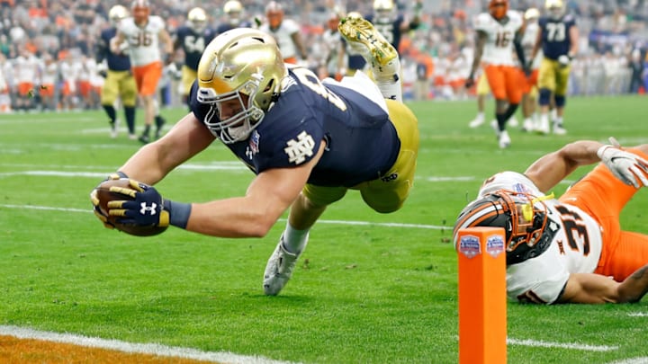 GLENDALE, ARIZONA – JANUARY 01: Michael Mayer #87 of the Notre Dame Fighting Irish dives to score a touchdown past Kolby Harvell-Peel #31 of the Oklahoma State Cowboys in the second quarter during the PlayStation Fiesta Bowl at State Farm Stadium on January 01, 2022 in Glendale, Arizona. (Photo by Christian Petersen/Getty Images)