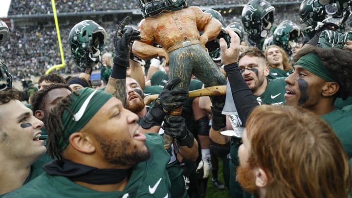 Oct 30, 2021; East Lansing, Michigan, USA; Members of the Michigan State Spartans hold up the Paul Bunyan trophy in celebration after the game against the Michigan Wolverines at Spartan Stadium. Mandatory Credit: Raj Mehta-USA TODAY Sports