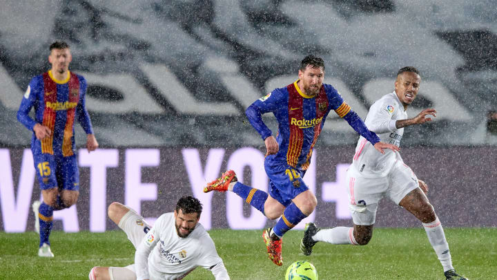 Lionel Messi of Barcelona gets past a Nacho Fernandez challenge as Eder Militao of Real Madrid chases during the April 10, 2021, Clasico in Madrid, Spain.  (Photo by Angel Martinez/Getty Images)