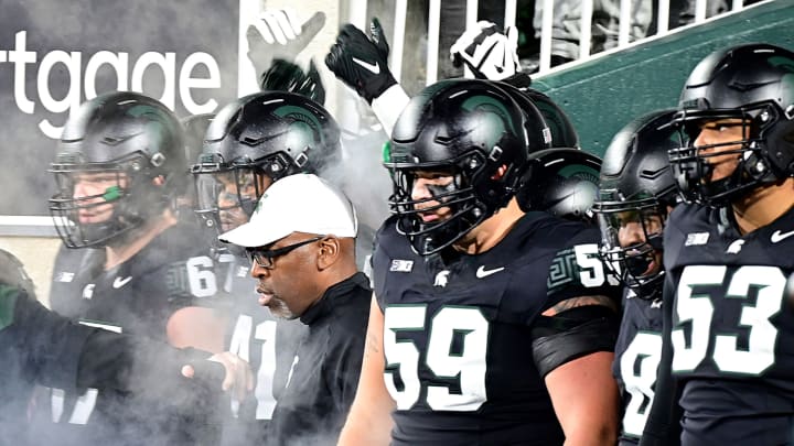 Oct 21, 2023; East Lansing, Michigan, USA; Michigan State Spartans head coach Harlan Barnett leads his team onto the field through a fog for their game against the Michigan Wolverines at Spartan Stadium. Mandatory Credit: Dale Young-USA TODAY Sports