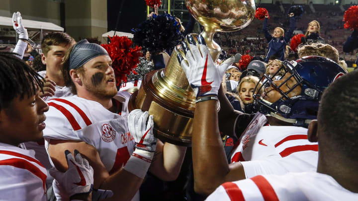STARKVILLE, MS – NOVEMBER 23: Mississippi Rebels players celebrate by hoisting the Egg Bowl trophy after defeating the Mississippi State Bulldogs 31-28 in an NCAA football game at Davis Wade Stadium on November 23, 2017 in Starkville, Mississippi. (Photo by Butch Dill/Getty Images)