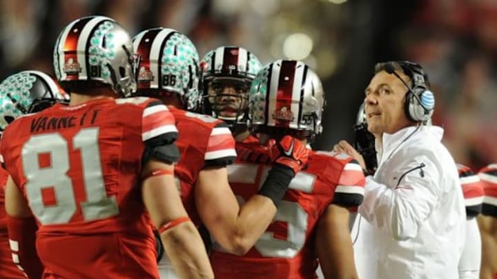 Jan 3, 2014; Miami Gardens, FL, USA; Ohio State Buckeyes head coach Urban Meyer (right) talks with his players in a timeout against Clemson Tigers during the first half in the 2014 Orange Bowl college football game at Sun Life Stadium. Mandatory Credit: Steve Mitchell-USA TODAY Sports