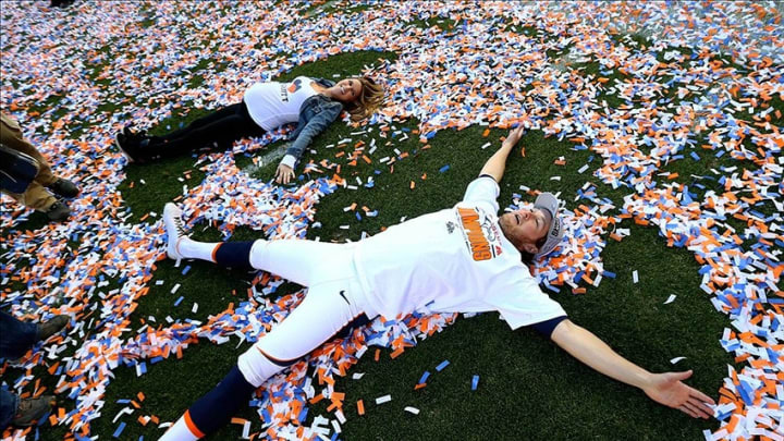Jan 19, 2014; Denver, CO, USA; Denver Broncos punter Britton Colquitt (near) does snow angels in the confetti with his pregnant wife Nikki Hairrell following the game against the New England Patriots during the 2013 AFC Championship football game at Sports Authority Field at Mile High. The Broncos defeated the Patriots 26-16. Mandatory Credit: Mark J. Rebilas-USA TODAY Sports