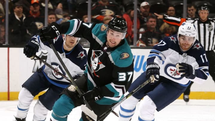 ANAHEIM, CA - MARCH 20: Nick Ritchie #37 of the Anaheim Ducks skates with the puck with pressure from Adam Lowry #17 of the Winnipeg Jets during the game on March 20, 2019 at Honda Center in Anaheim, California. (Photo by Debora Robinson/NHLI via Getty Images)