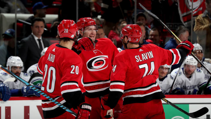 RALEIGH, NC – FEBRUARY 9: Brett Pesce #22 of the Carolina Hurricanes celebrates with teammates Jaccob Slavin #74 and Sebastian Aho #20 after scoring a goal during an NHL game against the Vancouver Canucks on February 9, 2018 at PNC Arena in Raleigh, North Carolina. (Photo by Gregg Forwerck/NHLI via Getty Images)