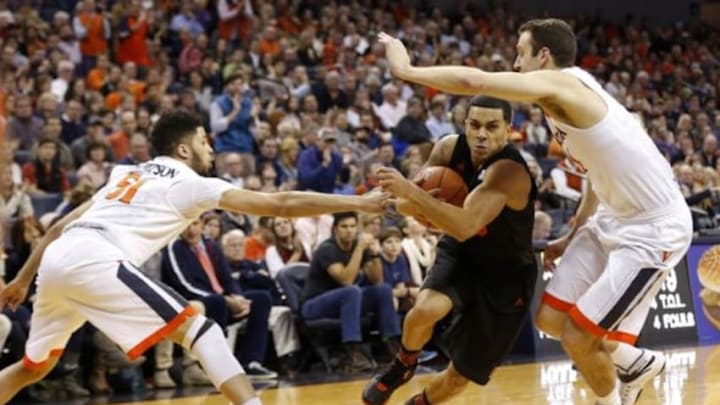 Jan 12, 2016; Charlottesville, VA, USA; Miami Hurricanes guard Angel Rodriguez (13) drives to the basket as Virginia Cavaliers guard Darius Thompson (51) and Cavaliers forward Evan Nolte (11) defend in the first half at John Paul Jones Arena. The Cavaliers won 66-58. Mandatory Credit: Geoff Burke-USA TODAY Sports