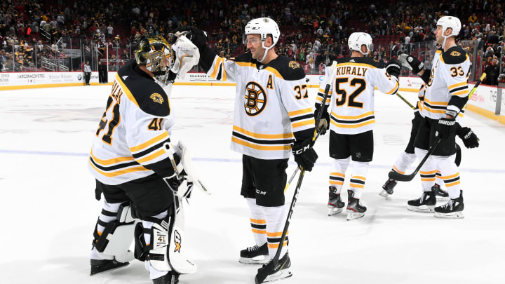GLENDALE, ARIZONA – OCTOBER 05: Goalie Jaroslav Halak #41 of the Boston Bruins is congratulated by teammate Patrice Bergeron #37 following a 1-0 victory against the Arizona Coyotes at Gila River Arena on October 05, 2019 in Glendale, Arizona. (Photo by Norm Hall/NHLI via Getty Images)