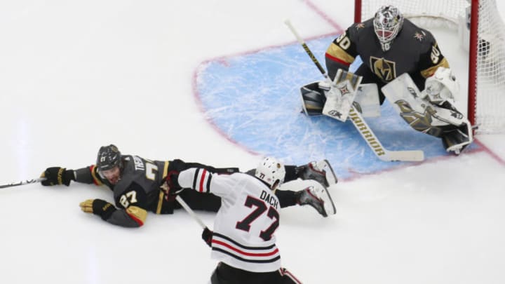 Shea Theodore #27 of the Vegas Golden Knights dives on the ice to try and block a shot on goal tender Robin Lehner #90 by Kirby Dach #77 of the Chicago Blackhawks during the third period in Game One of the Western Conference First Round. (Photo by Jeff Vinnick/Getty Images)