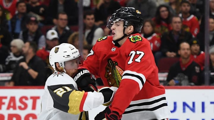 CHICAGO, ILLINOIS - OCTOBER 22: Kirby Dach #77 of the Chicago Blackhawks collides with Cody Eakin #21 of the Vegas Golden Knights during the third period at the United Center on October 22, 2019 in Chicago, Illinois. (Photo by Stacy Revere/Getty Images)