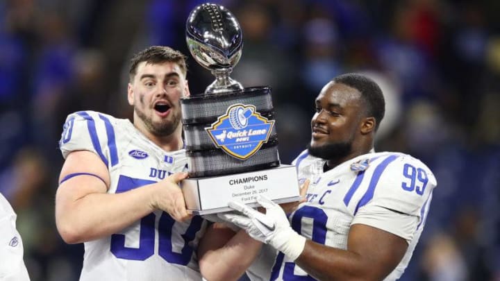 DETROIT, MI - DECEMBER 26: Austin Davis #50 and Mike Ramsay #99 of the Duke Blue Devils celebrate with the trophy after defeating the Northern Illinois Huskies 36-14 in the Quick Lane Bowl at Ford Field on December 26, 2017 in Detroit Michigan. (Photo by Gregory Shamus/Getty Images)