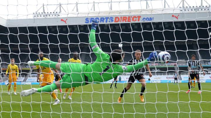 NEWCASTLE UPON TYNE, ENGLAND – APRIL 04: Hugo Lloris of Tottenham Hotspur makes a save from Dwight Gayle of Newcastle United during the Premier League match between Newcastle United and Tottenham Hotspur at St. James Park on April 04, 2021 in Newcastle upon Tyne, England. Sporting stadiums around the UK remain under strict restrictions due to the Coronavirus Pandemic as Government social distancing laws prohibit fans inside venues resulting in games being played behind closed doors. (Photo by Peter Powell – Pool/Getty Images)