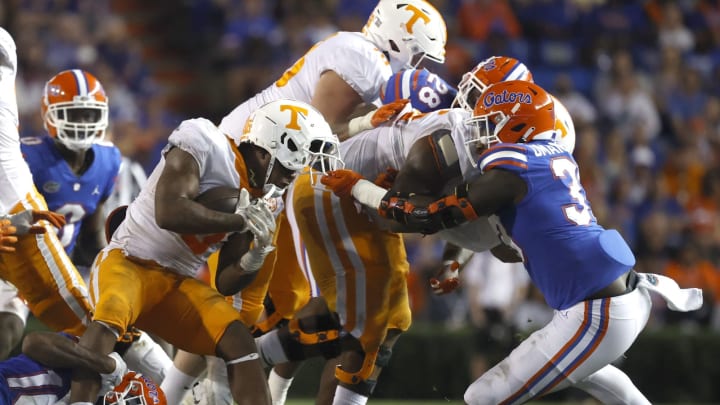 Sep 25, 2021; Gainesville, Florida, USA; Tennessee Volunteers running back Tiyon Evans (8) runs with the ball as Florida Gators defensive lineman Princely Umanmielen (33) tackles with he face mask during the fourth quarter at Ben Hill Griffin Stadium. Mandatory Credit: Kim Klement-USA TODAY Sports