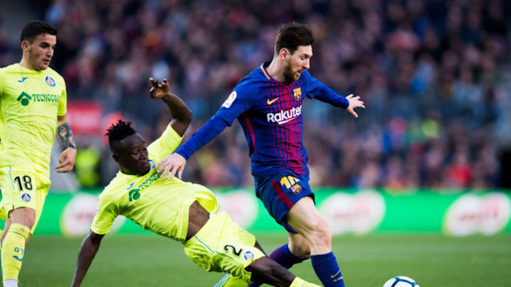 BARCELONA, SPAIN - FEBRUARY 11: Djene Dakonam of Getafe CF tackles Lionel Messi of FC Barcelona during the La Liga match between Barcelona and Getafe at Camp Nou on February 11, 2018 in Barcelona, Spain. (Photo by Alex Caparros/Getty Images)