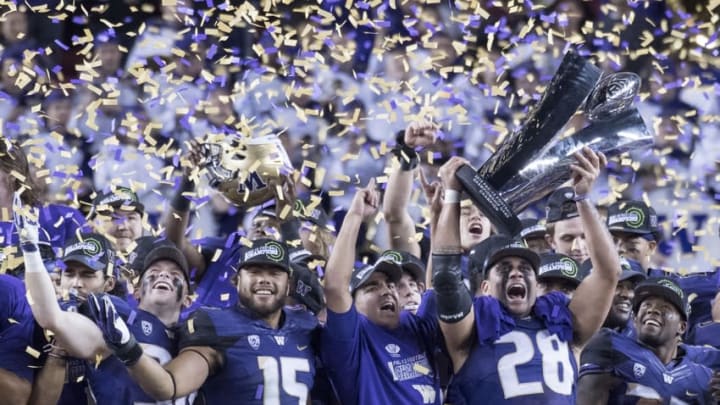 December 2, 2016; Santa Clara, CA, USA; Washington Huskies linebacker Psalm Wooching (28) hoists the championship trophy after the Pac-12 championship against the Colorado Buffaloes at Levi