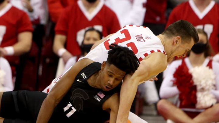 Jan 21, 2022; Madison, Wisconsin, USA; Michigan State Spartans guard A.J. Hoggard (11) and Wisconsin Badgers center Chris Vogt (33) fight for a loose ball during the first half at the Kohl Center. Mandatory Credit: Mary Langenfeld-USA TODAY Sports