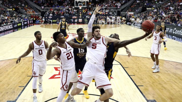 KANSAS CITY, MISSOURI - MARCH 13: Matt Freeman #5 of the Oklahoma Sooners and Andrew Gordon #12 of the West Virginia Mountaineers compete for a rebound during the first round game of the Big 12 Basketball Tournament at the Sprint Center on March 13, 2019 in Kansas City, Missouri. (Photo by Jamie Squire/Getty Images)