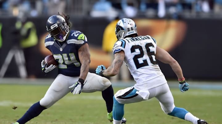 Jan 17, 2016; Charlotte, NC, USA; Seattle Seahawks running back Marshawn Lynch (24) carries the ball defended by Carolina Panthers defensive back Cortland Finnegan (26) in the third quarter during the NFC Divisional round playoff game at Bank of America Stadium. Mandatory Credit: Bob Donnan-USA TODAY Sports
