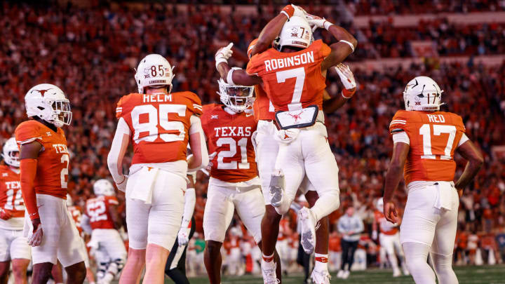 AUSTIN, TEXAS – NOVEMBER 24: Keilan Robinson #7 of the Texas Longhorns is congratulated by teammates after scoring a touchdown in the third quarter against the Texas Tech Red Raiders at Darrell K Royal-Texas Memorial Stadium on November 24, 2023 in Austin, Texas. (Photo by Tim Warner/Getty Images)